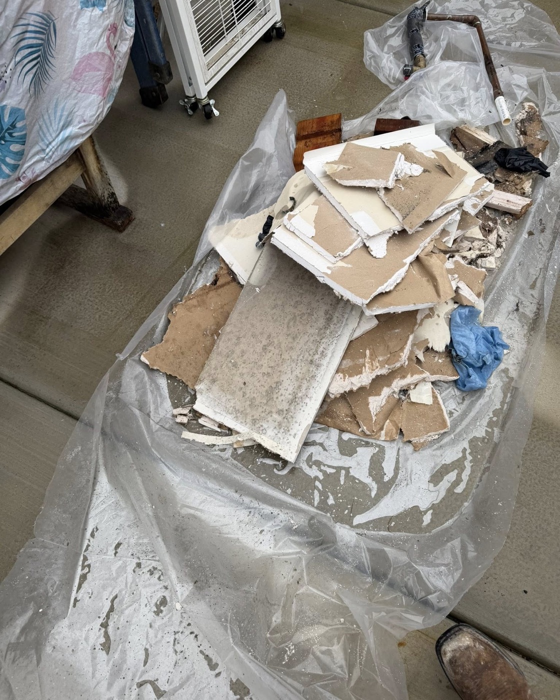 Drywall demolition debris bagged on protective containment plastic