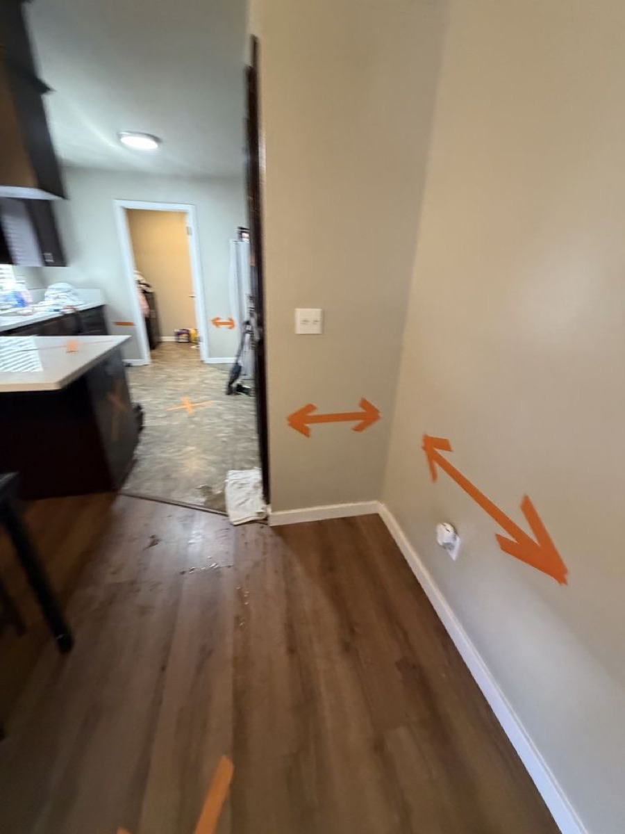 Floor marked with moisture mapping indicators during water damage assessment